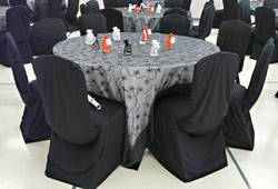 Table with silver cloth and black chair covers