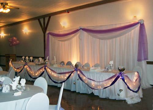 head table with lights and ribbon draping