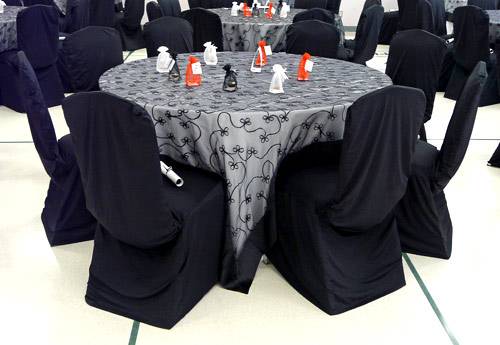 Table with silver cloth and black chair covers