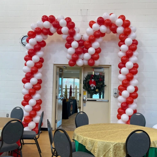 red and white balloon arch in candycane shape