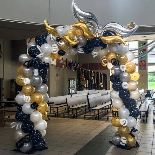 white, black, and gold balloon arch