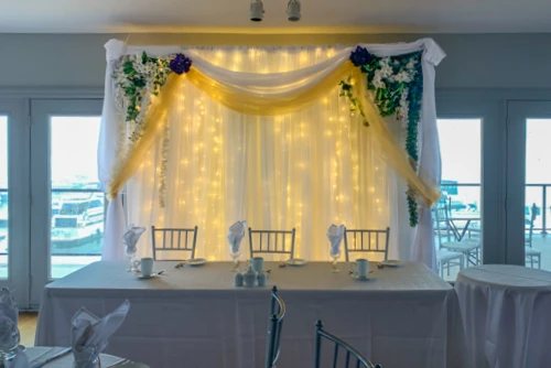 organza backdrop with gold draping and greenery