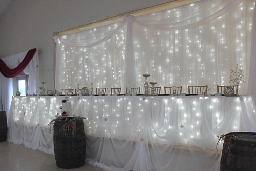 head table with organza backdrop and lights