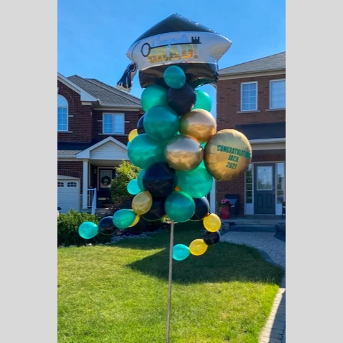 green and gold outdoor balloon grad announcement