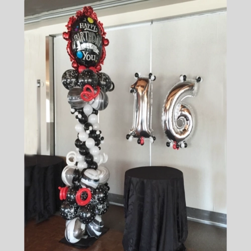 black, red, and white birthday balloon column