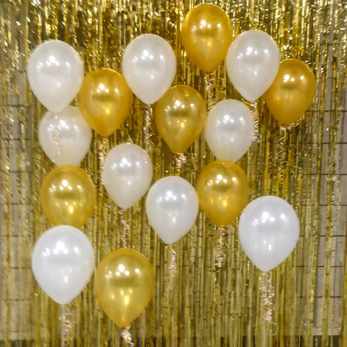gold and white balloons in front of gold backdrop