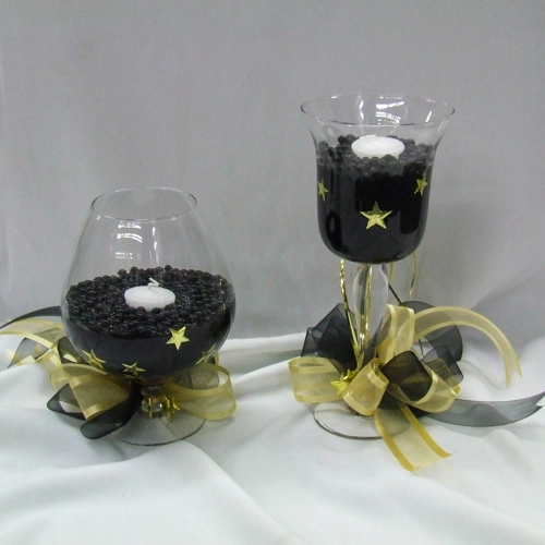 centrepieces with black pebbles in glasses with tea lights