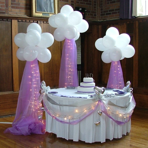 cake table with purple accents and balloon clouds