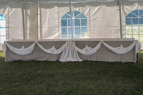 head table decor in white tent with cathedral windows