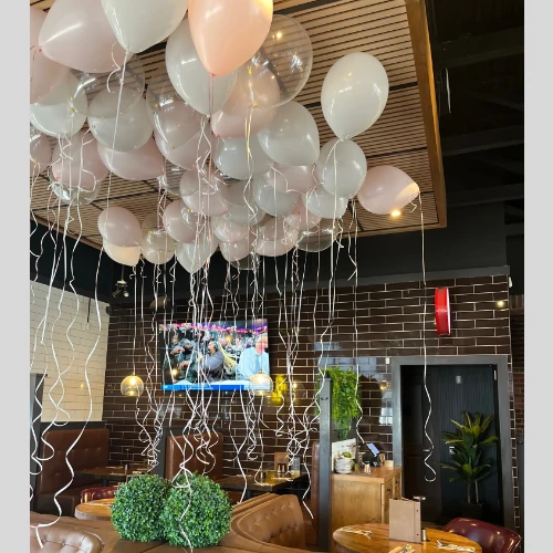 pink and white balloon ceiling with long ribbons
