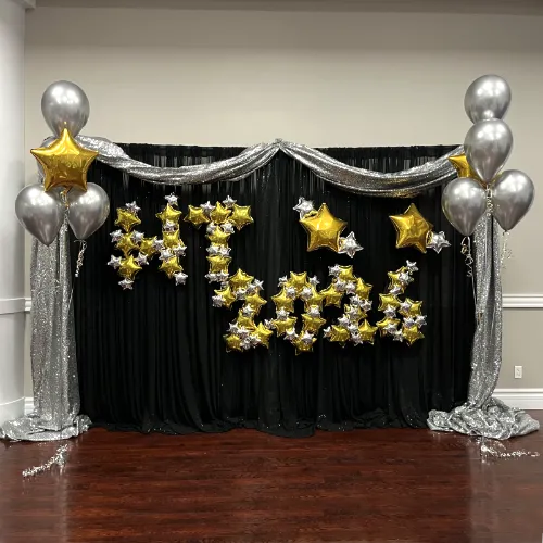 High school prom decor for Starry Nights theme--gold and silver balloons and black and silver draping