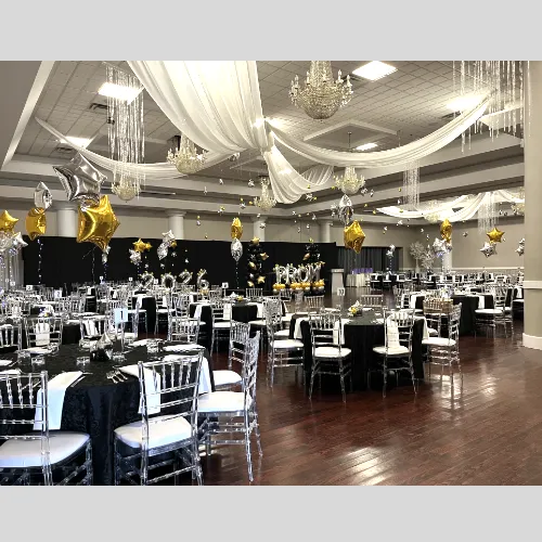 Prom decor for Starry Nights theme, with ceiling draping and clear chiavari chairs. Gold and silver foil balloons.