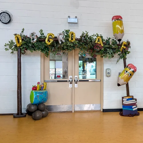 entrance decor for Education Gala, with school supplies balloons and mylar letters